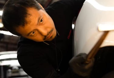 Professional pdr technician blending a panel with hammer