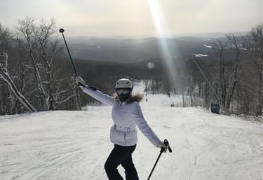 Female skier in a white jacket and helmet posing on a snowy mountain ski  resort Lake Louise Canada