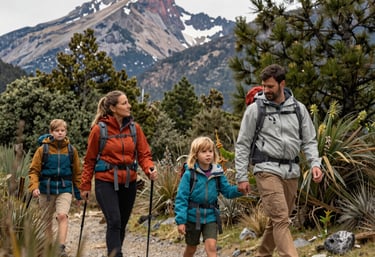 Family hiking together on a lush forest trail in the Valle de Patagual during autumn.