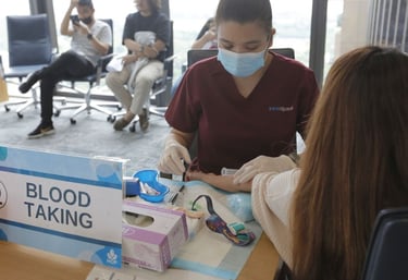 A nurse taking blood from a health screening participant.