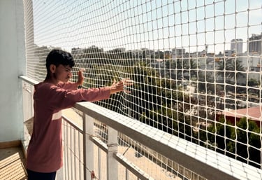 A bright balcony secured with a tightly woven safety net, sunlight streaming through.