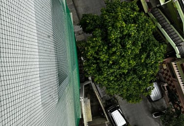 A happy child playing safely behind a well-installed safety net on a residential balcony.