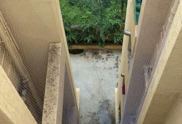Technician carefully installing a durable safety net over a duct area in a Bannerghatta building.