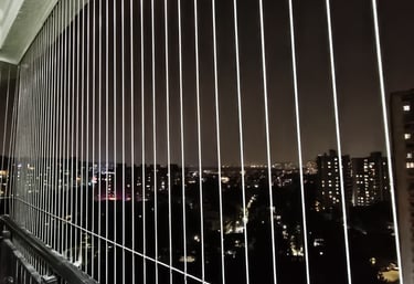 Wide shot of a modern apartment balcony in Bengaluru fitted with transparent safety grills.