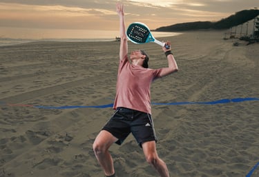 Jogador avançado executando um smash do fundo da quadra, numa partida de beach tennis.