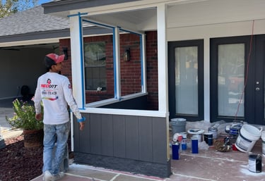 Professional house painter preparing a residential porch for exterior painting services.