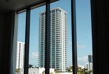 A sunny view through a large window of a modern Miami building, showing a clear blue sky, emphasizing indoor air quality and comfort.