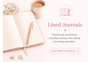 An open pink lined journal on a desk with a gold pen, coffee mug, and floral accents.