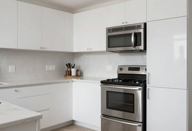 A sparkling clean, minimalist kitchen with stainless steel appliances and white cabinetry in a modern North American home.