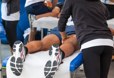 Terapeuta de masaje deportivo profesional que trata los músculos de las piernas de un atleta