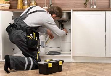 plumber fixing kitchen pipes and fixtures in an Auckland home