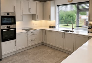 Light grey shaker kitchen cabinets with quartz worktops and integrated double oven fitted in Oxford.