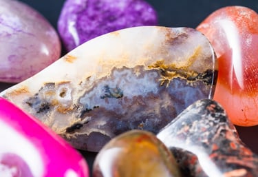 Piedras pulidas y cristales de ágata coloridos con patrones minerales únicos para sanación.