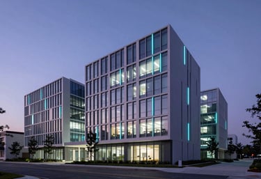 A professional architectural photograph of a minimalist, high-tech campus building in the US at dusk, glowing with subtle electric cyan and purple lights.