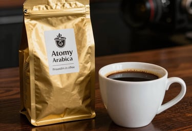 A warm, detailed shot of a cup of healthy Atomy Arabica coffee beside its premium gold-leaf packaging on a polished dark wood surface.