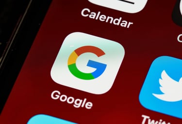 Close-up of the Google search app icon on a smartphone screen next to Twitter and Calendar.