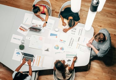 Diverse team collaborating on a marketing strategy and data analysis at a modern office table.