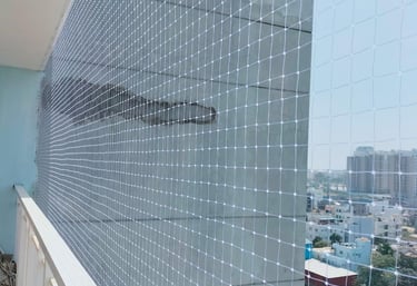 Technician carefully installing a safety net on a residential balcony.