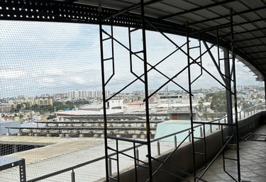 Workers installing a heavy-duty safety net on a construction site in Chennai.