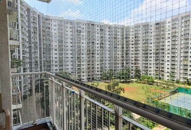 Technician from Arjilli Enterprises fitting a safety net on a high-rise balcony.