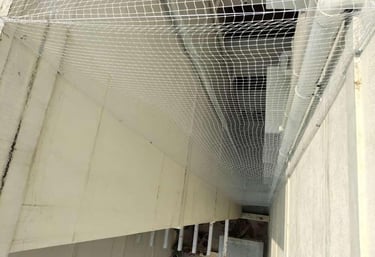 Close-up of a securely installed pigeon net over an apartment duct in Thoraipakkam.