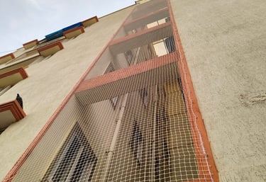 Wide shot showing pigeon nets covering apartment ducts to keep birds away.