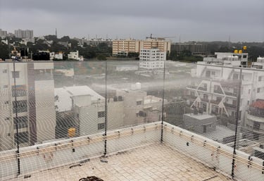 A technician carefully installing a sturdy sports net on a sunny Chennai terrace.