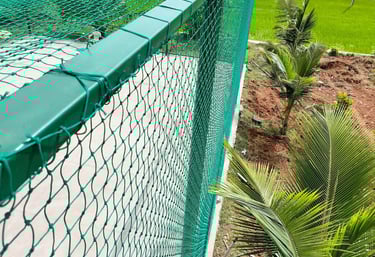 A rooftop cricket net installation with a clear blue sky in Bengaluru.