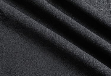 A detailed texture shot of natural linen fabric in a light charcoal black shade. The weave is visible and uniform, showing off the high-quality craftsmanship.