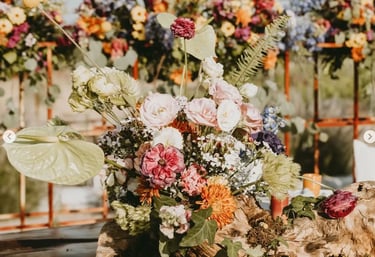 Arreglo floral abundante con rosas y flores silvestres en tonos variados.