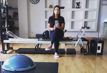 Pilates instructor Maalini sitting in the studio taking a relaxed selfie at The Pilates Room Bangsar