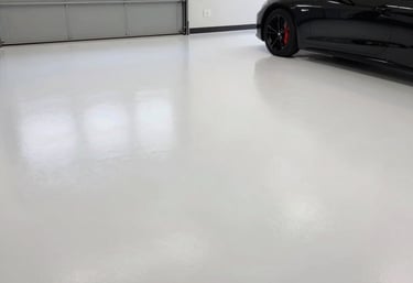 A freshly finished high-end residential garage with glossy metallic epoxy flooring and custom storage solutions.