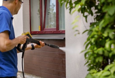 a man in a blue shirt is using a power washer