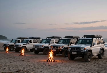 A cinematic shot of a fleet of 4WD vehicles parked on a beach at dusk, with small campfires starting to glow. The scene represents a coordinated brand expedition.