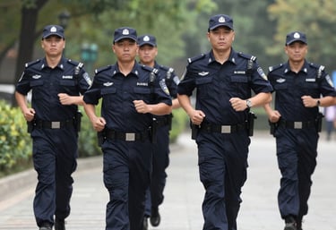 A professional security guard in a sleek blue uniform standing confidently in front of a modern building.