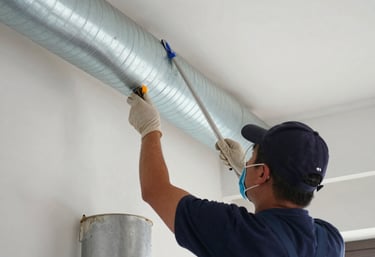 Technician carefully inspecting an air duct system with a camera in a bright, modern home interior.
