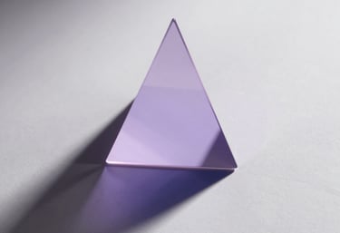 A conceptual photo of light reflecting off a prism, casting lavender and navy shadows across a clean ghost white wall.