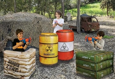 A photo showing children playing with Nerf guns and hiding behind inflatable barriers
