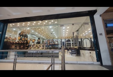 A luxury jewelry store storefront featuring elegant gold necklaces and diamond jewelry on display behind glass.