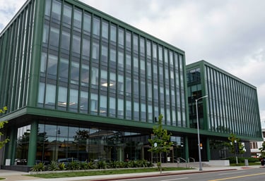 A wide-angle view of a professional North American / European world-class corporate headquarters with modern glass architecture and matte forest green elements.