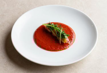 A minimalist plating of a modern dish in a North American / US restaurant. White ceramic plate, vivid red sauce, and fresh herbs. Crisp Parchment background, top-down photography.