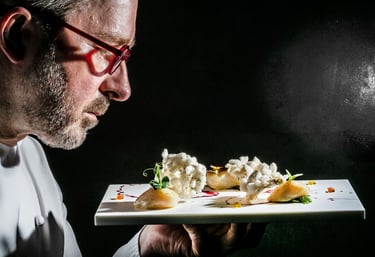 a man in a white shirt and glasses is holding a plate with food