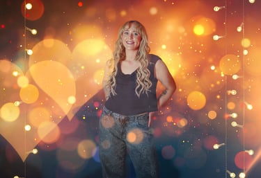 Smiling blonde woman posing in front of festive bokeh heart lights and golden holiday glitter.
