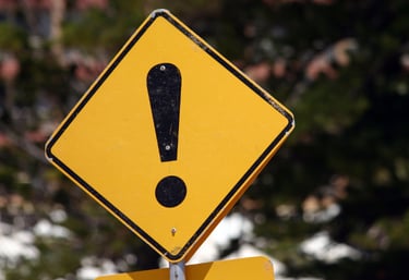 a yellow caution sign with a black and white exclamail