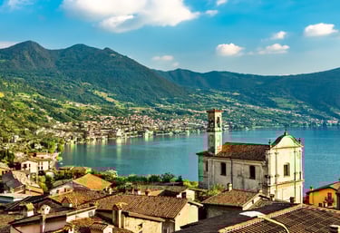 Panoramic view of Lovere on Lake Iseo in Lombardy, Italy, showing terracotta rooftops, a historic church, and the calm blue l