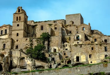 Historic ruins of Craco ghost town on a steep hill in Basilicata, Italy, with ancient stone houses and church tower