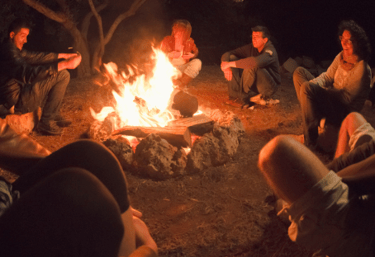 People sitting around a campfire at night