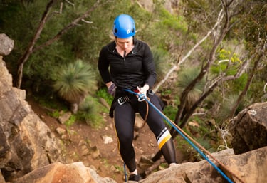 Abseiling down a cliff in South Australia, experiencing the thrill of safe, controlled descent.