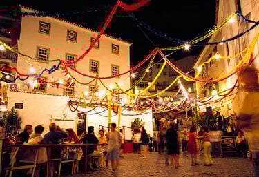 a group of people sitting at tables in a street party