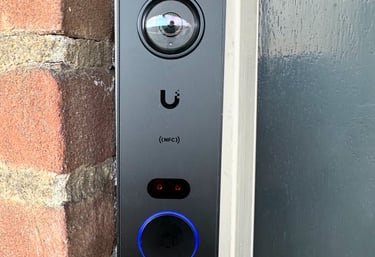 Ubiquiti UniFi G6 Doorbell Pro with camera and NFC reader installed on a brick doorframe.
